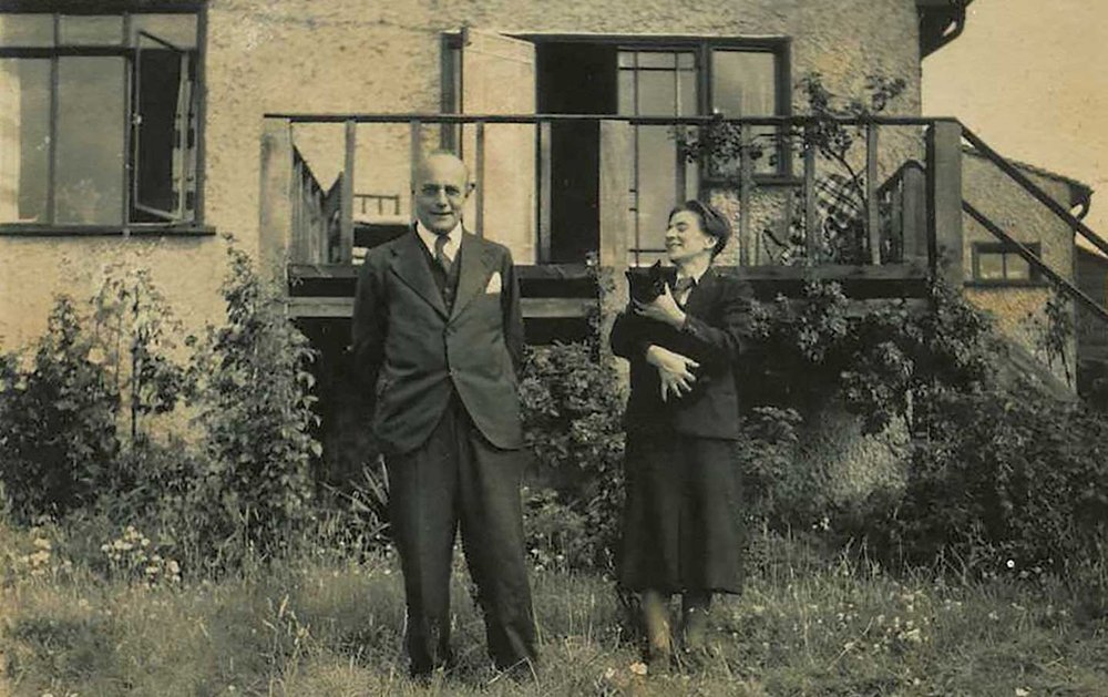 Karl Polanyi and Ilona Duczyńska in front of their house, with a black cat in Ilona's arms