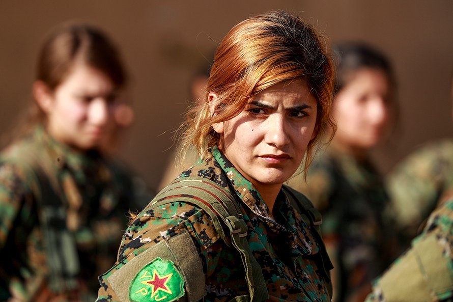 YPJ fighter in close-up, direct gaze, with the YPJ patch visible on her shoulder